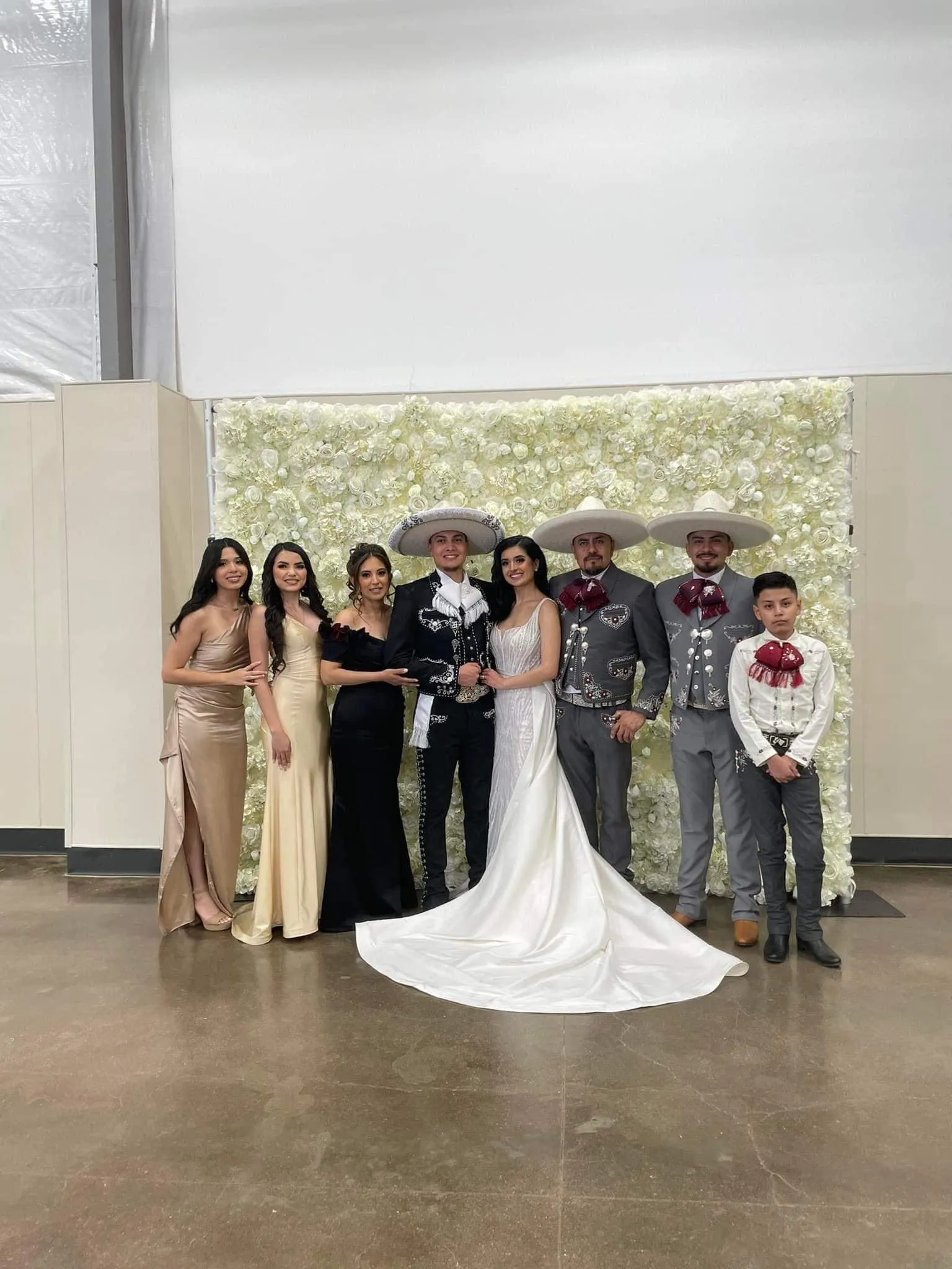 Wedding party gathered in front of the flower wall